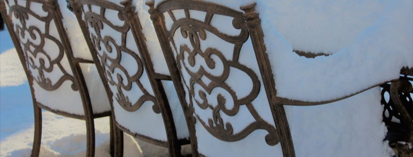 Outdoor chairs filled with snow