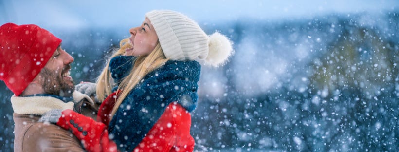 Young couple enjoying snowfall