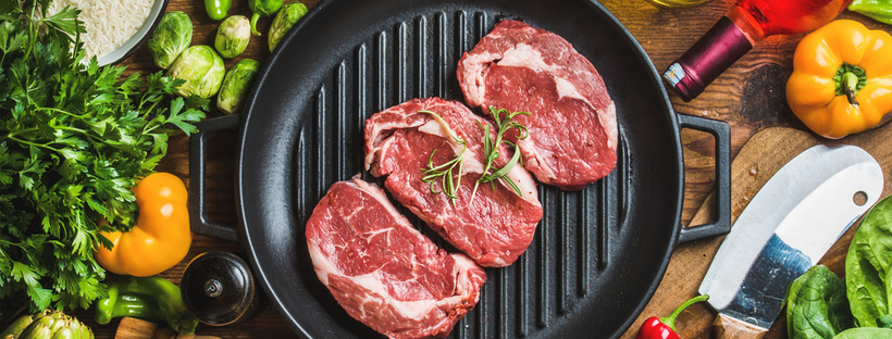 Raw steaks on a skillet